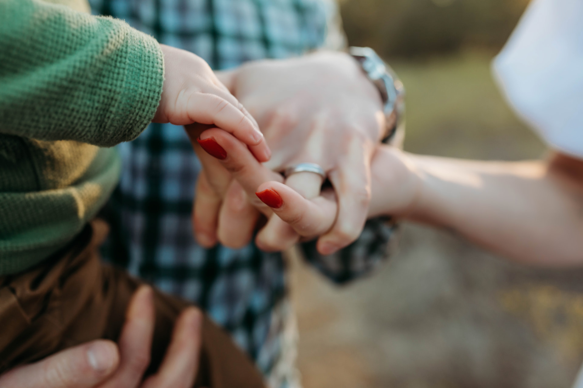 The family's hands stacked together on a walk
