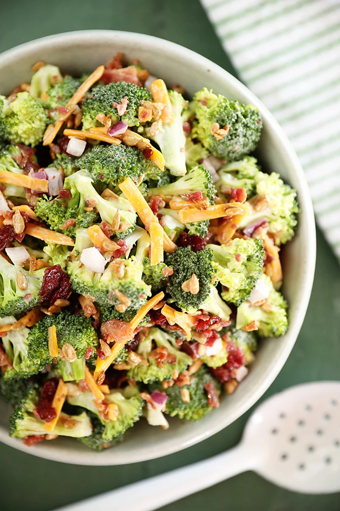 Tangy broccoli salad with bacon, sharp cheddar and sunflower kernels in a large bowl