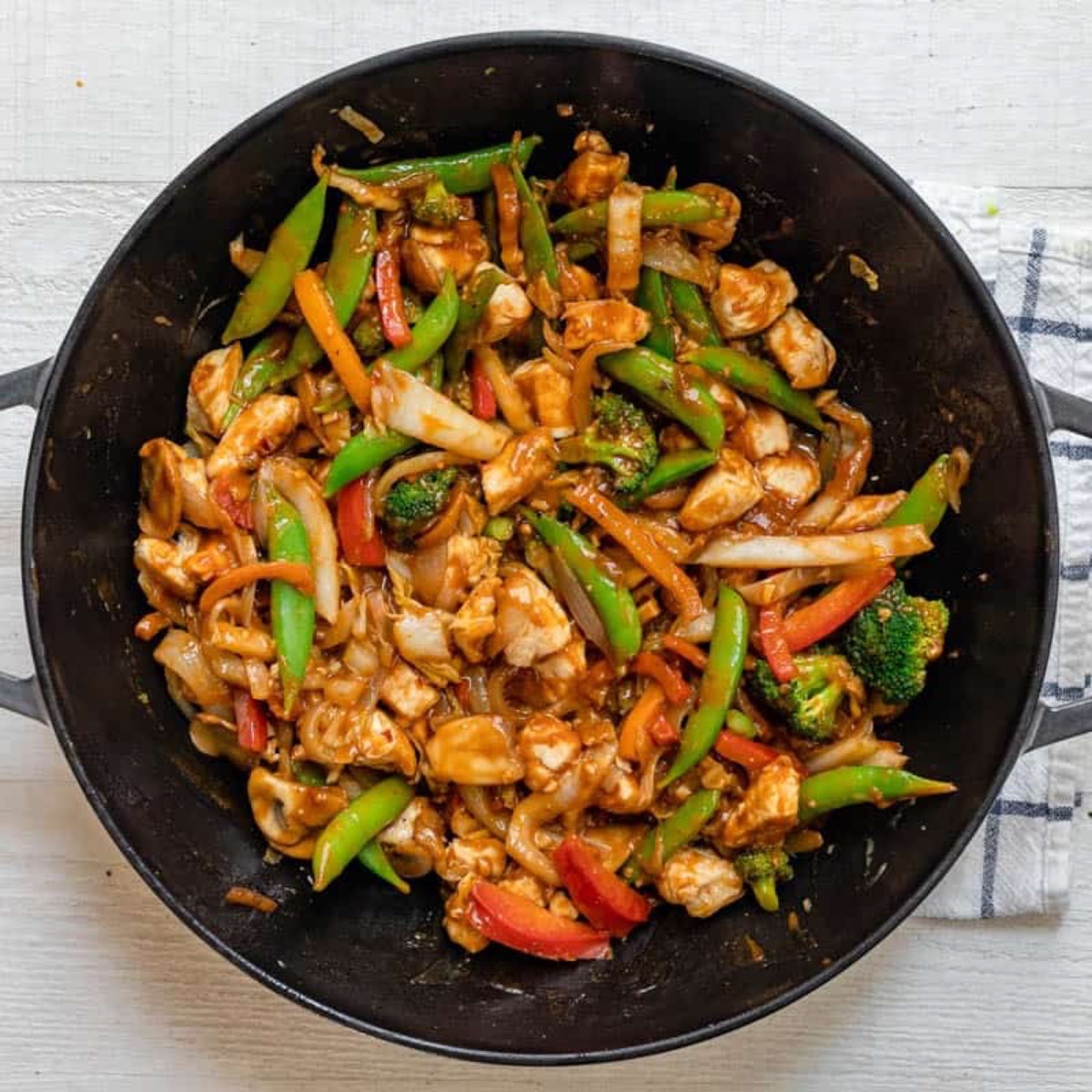 Thai peanut chicken stir fry with mixed vegetables and homemade peanut sauce in a wok